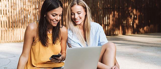 Two girls looking at information on a laptop